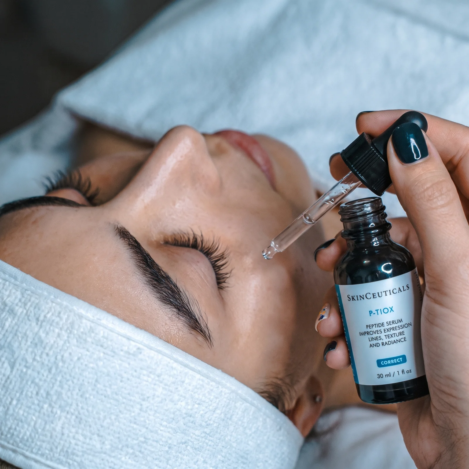 A SkinCeuticals serum being applied during a facial treatment