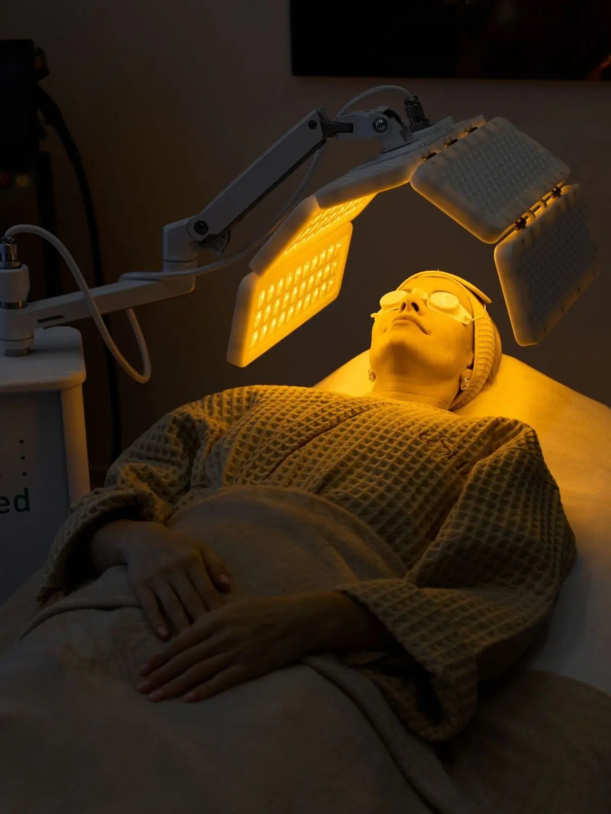 Patient during an LED light therapy session, face lit in red light
